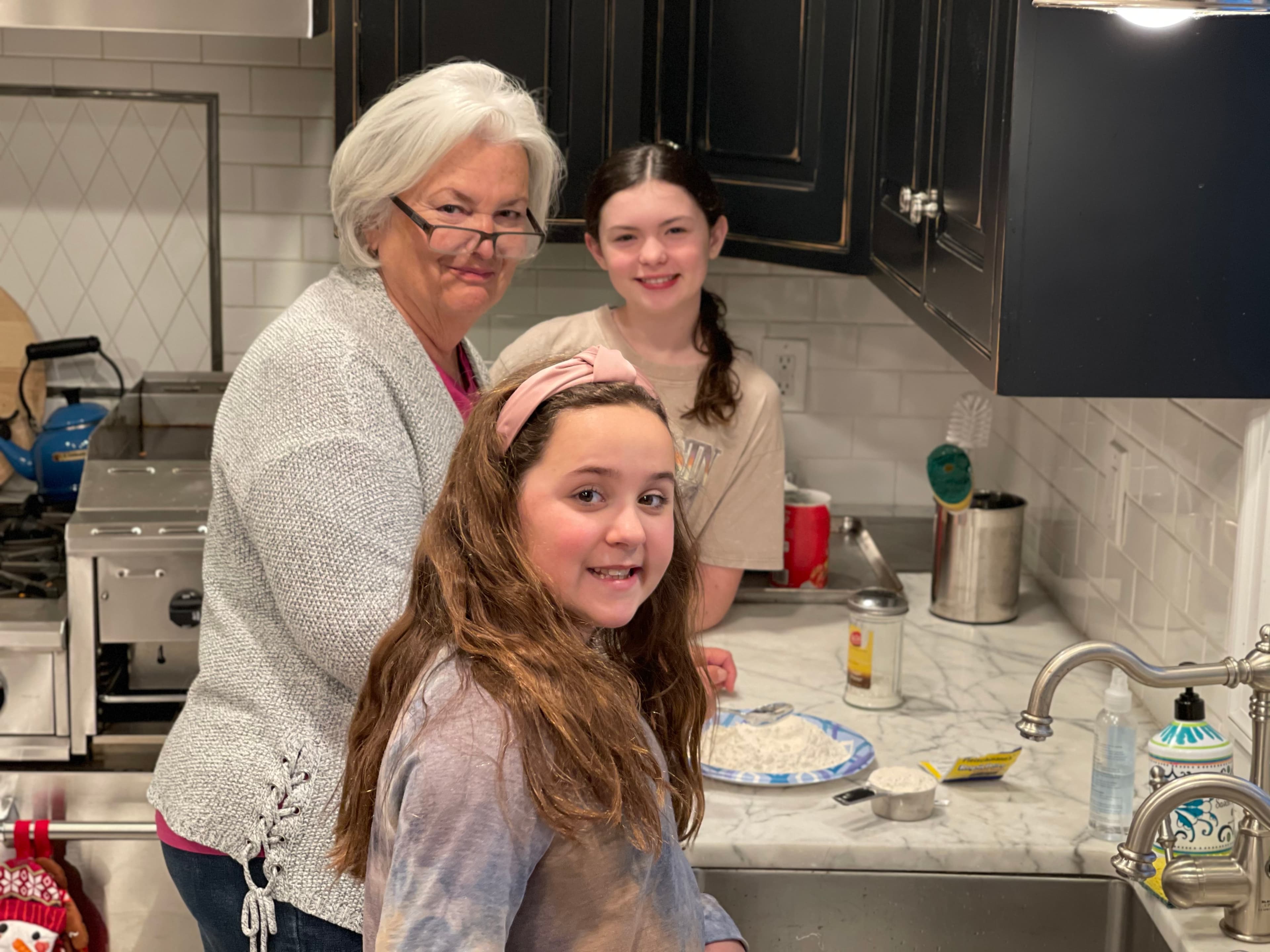 Grandma cooking with grandchildren in the kitchen