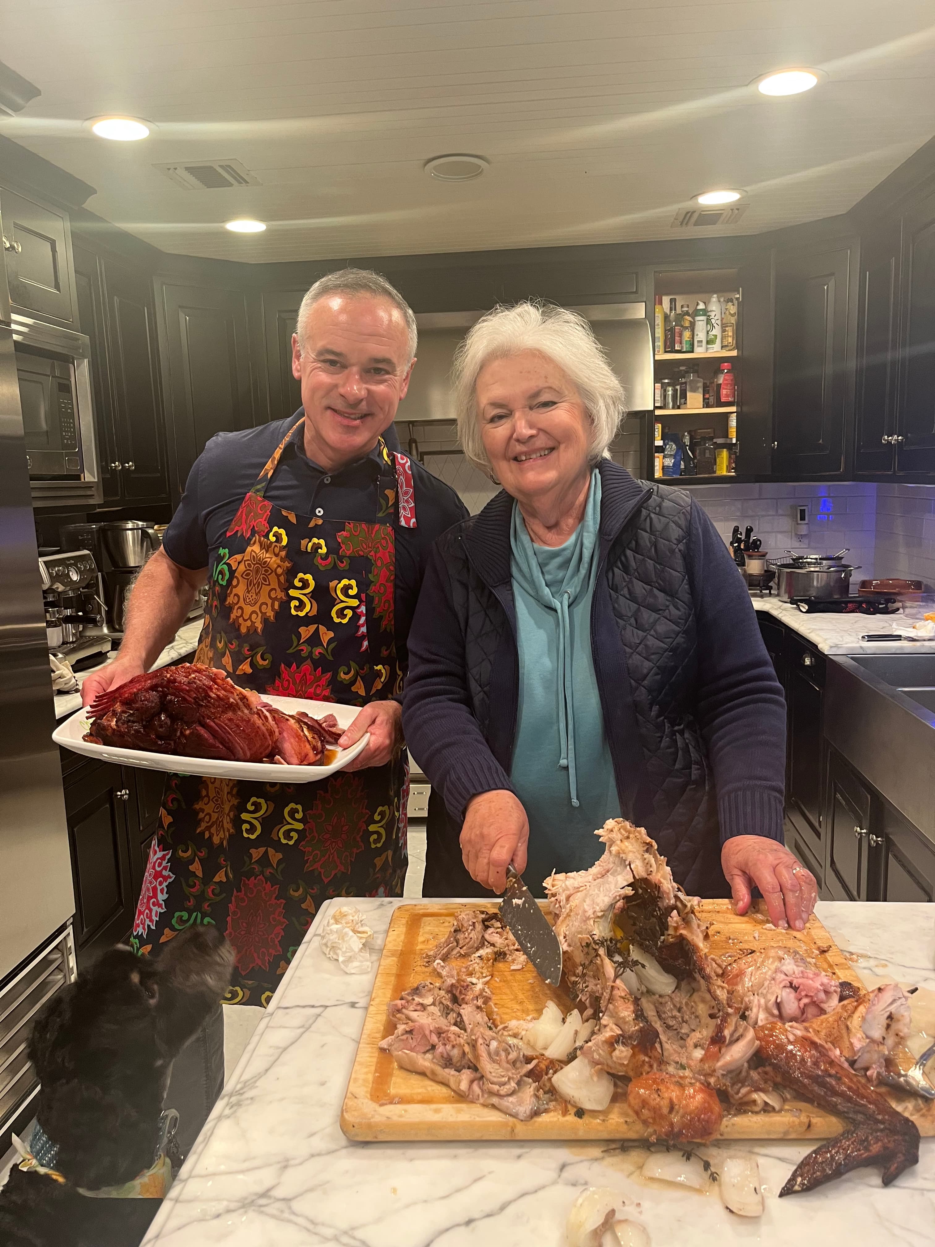George and his mom carving turkey at Thanksgiving